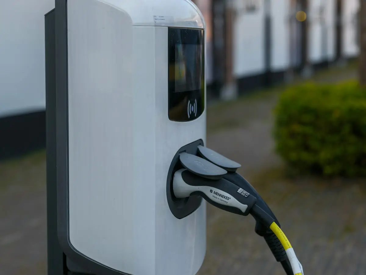 Electric vehicle charging station with cable plugged in (stock photo)
