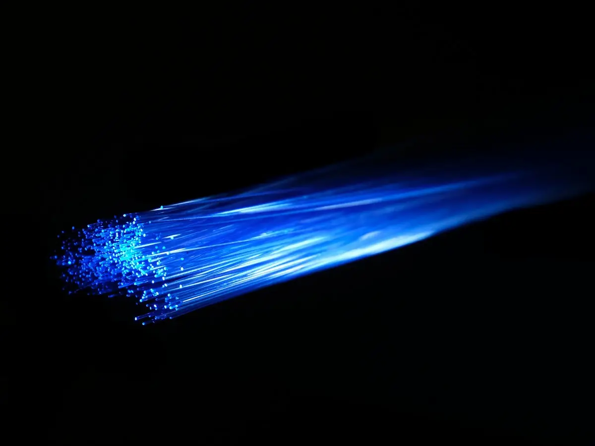 Blue light passing along a fiber optic cable (stock photo)